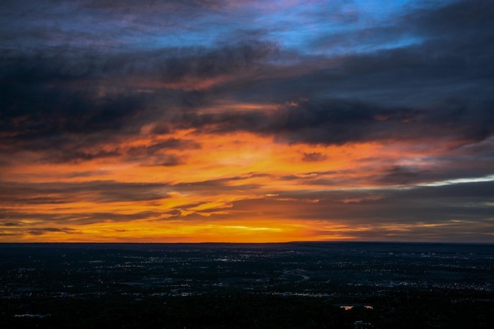 Sunset over a city skyline with colorful clouds