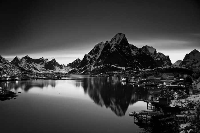 Monochrome landscape of mountains reflecting in a lake at dusk