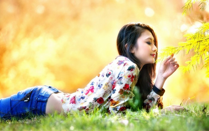 Woman in Floral Blouse Lying in a Sunlit Park