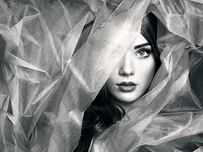 Monochrome portrait of a woman partially covered by fabric
