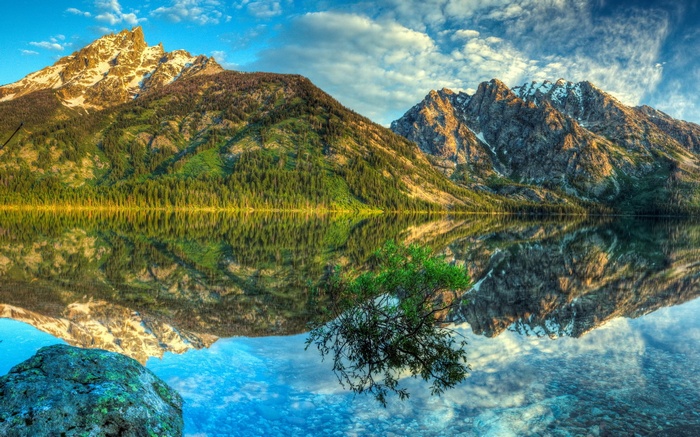 Mountains reflected in a calm lake at sunrise