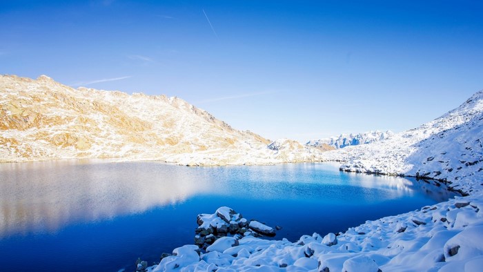Snow-covered mountains and a blue lake in winter