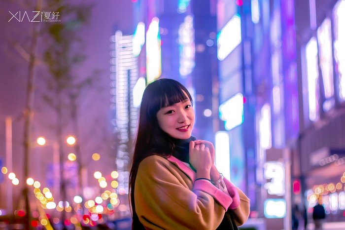 Young Asian woman posing at night with city lights