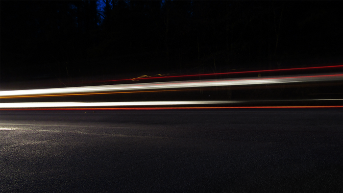 Light trails on a dark road at night