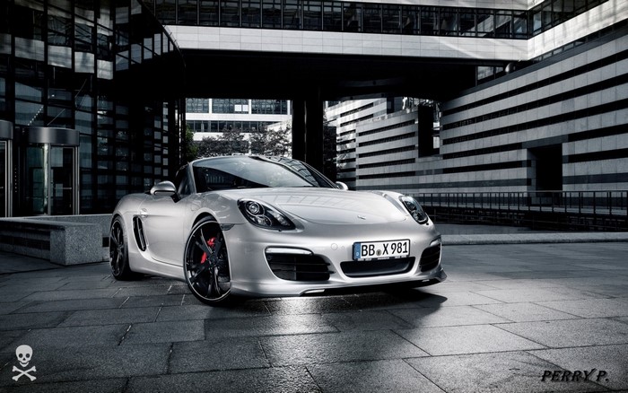 Silver Porsche Boxster parked in front of a modern building
