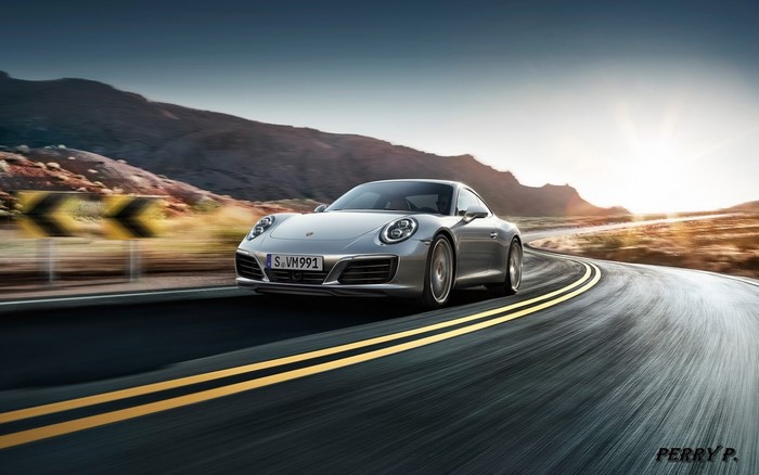 Silver Porsche 911 driving on a winding road