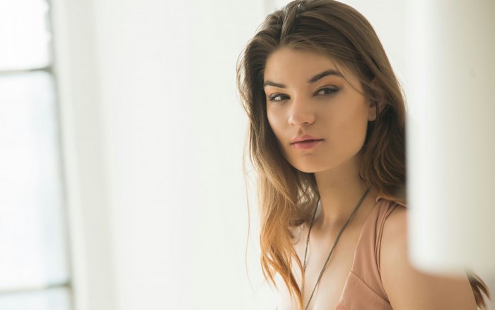 Woman with long brown hair looking away