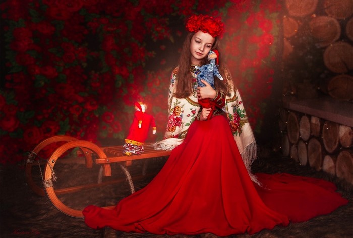 Girl in traditional dress holding a doll