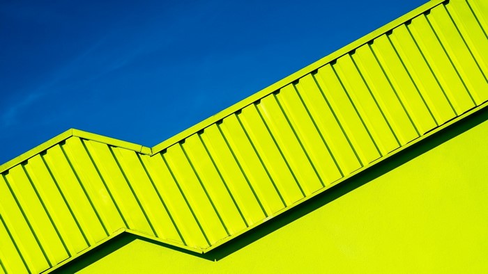 Abstract geometric shapes of a yellow building against a blue sky