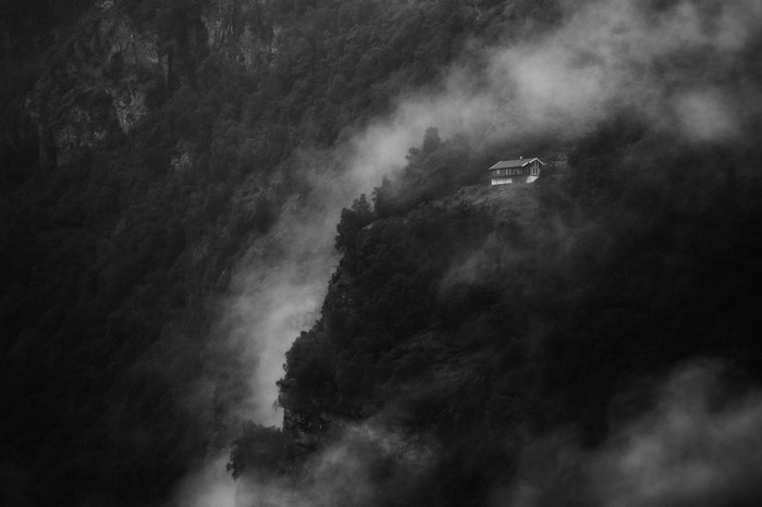 House on a cliff in mist, Norway