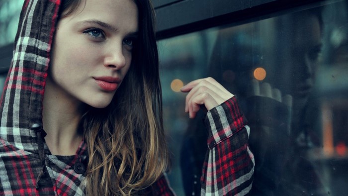 Woman with blue eyes wearing a plaid hooded jacket