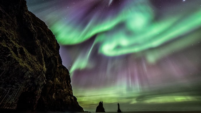 Aurora Borealis over a rocky coast at night