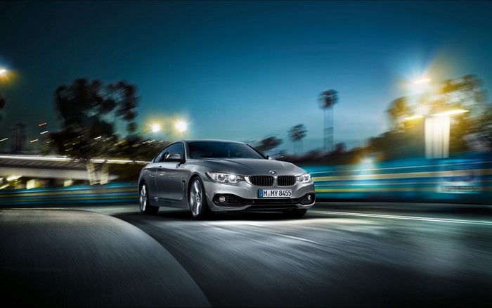 Silver BMW 4 Series Coupe driving at night
