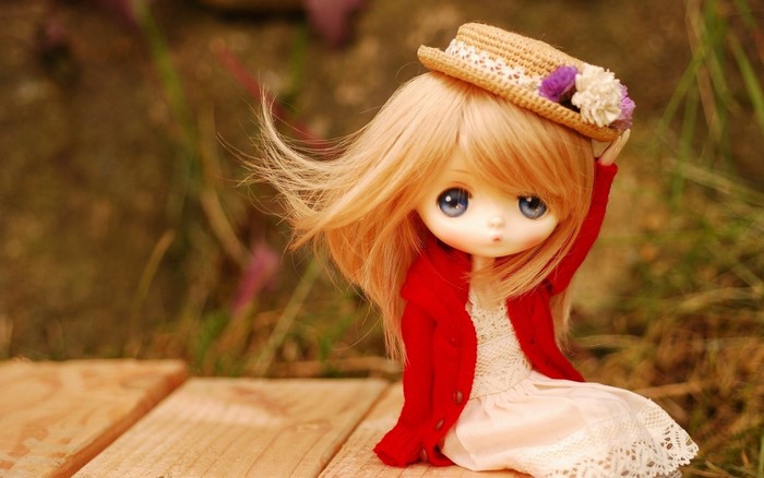Blonde doll wearing a red jacket and straw hat