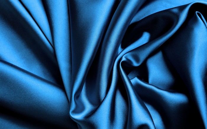 Blue satin fabric with folds and shadows