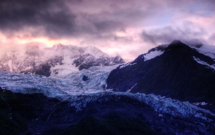 Glacier and mountains at dawn with dramatic clouds