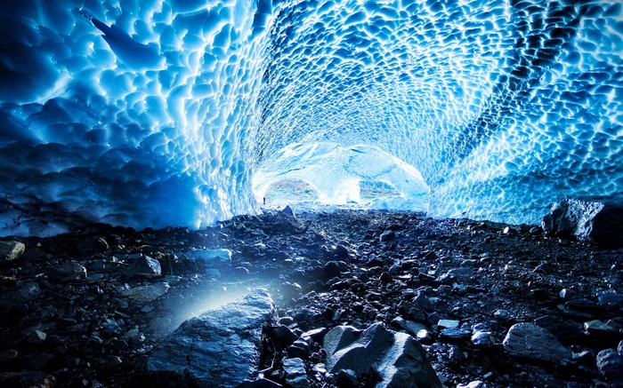 Ice cave with rocky floor and person