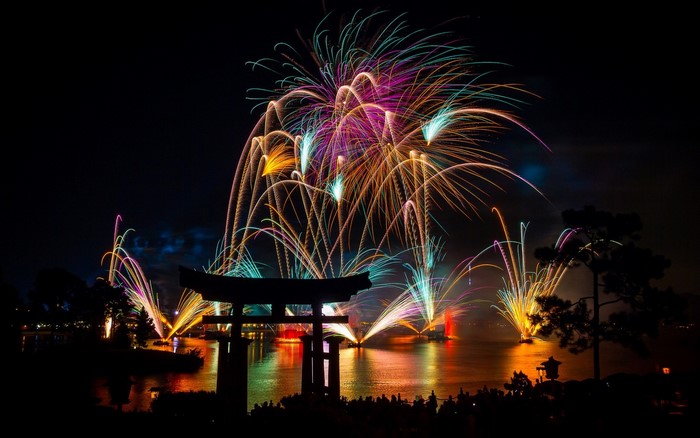 Fireworks over water with Japanese Torii gate