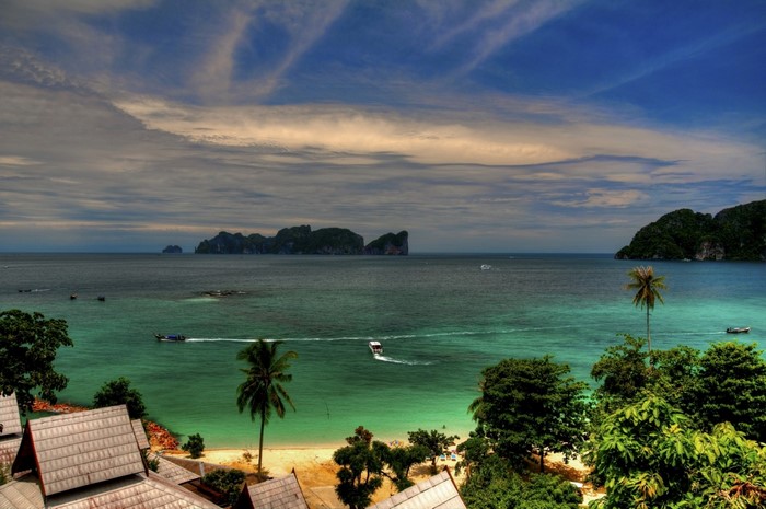 Tropical island bay with boats and palm trees