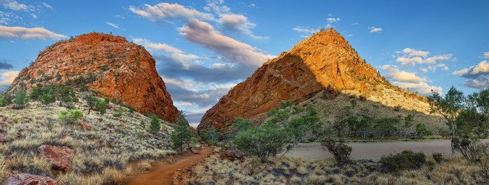 Red rock formations in a desert valley under a cloudy sky
