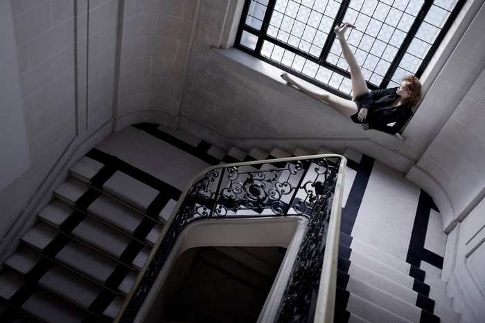 Woman posing on a staircase window