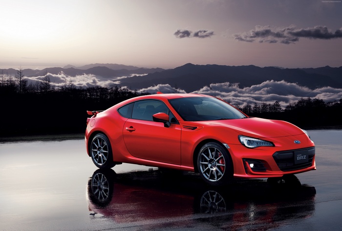 Red Subaru BRZ GT on wet surface with mountains