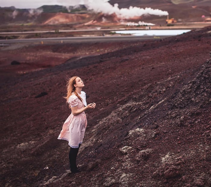 Girl in pink dress in volcanic landscape