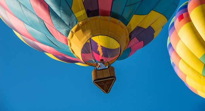 Hot air balloons in flight with a person in a basket