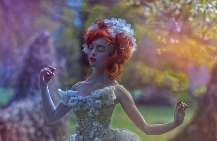 Woman with red hair and flower crown in a garden