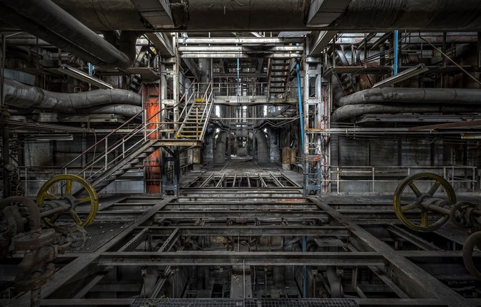 Abandoned industrial factory interior with pipes and machinery