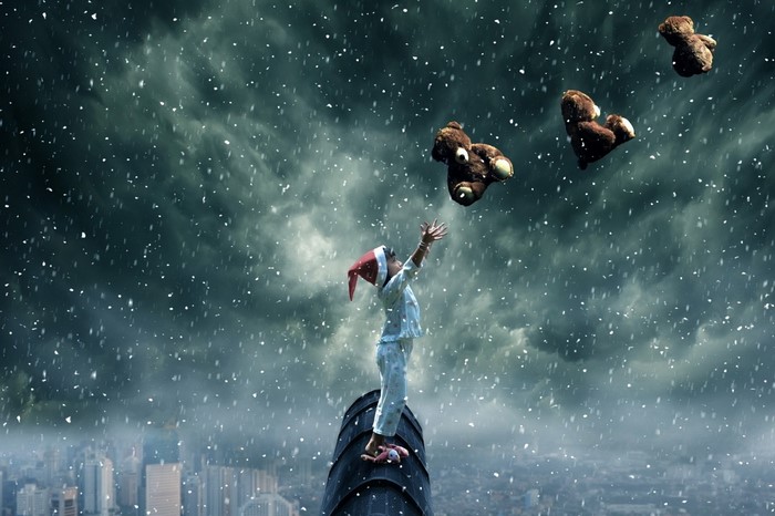Child in Santa hat throwing teddy bears in snow