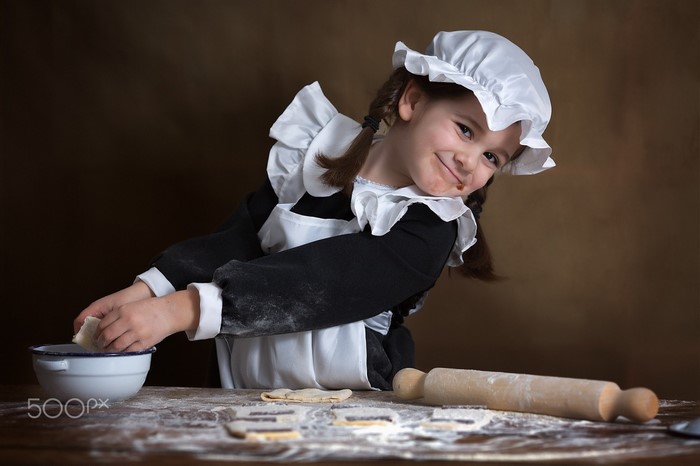 Girl in maid costume baking cookies