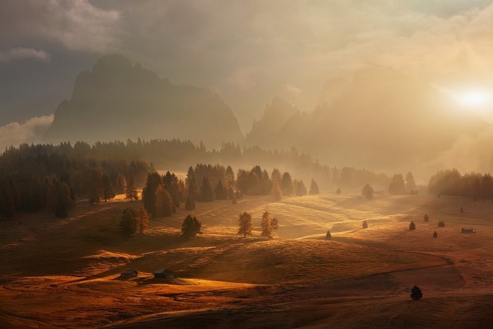 Misty mountain landscape at sunrise with golden light