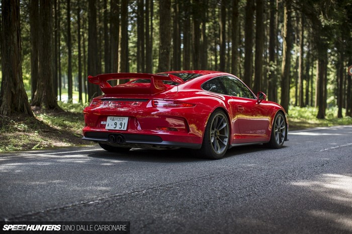 Red Porsche 911 GT3 on a forest road