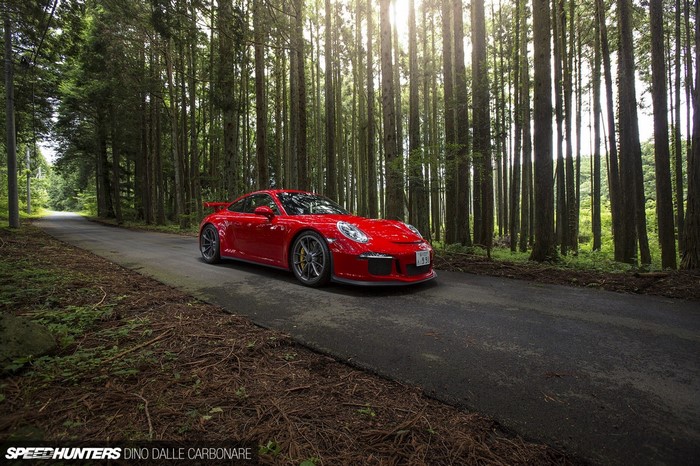 Red Porsche 911 GT3 on a forest road