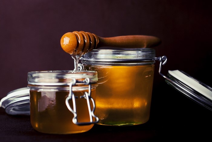 Honey in glass jars with a honey dipper