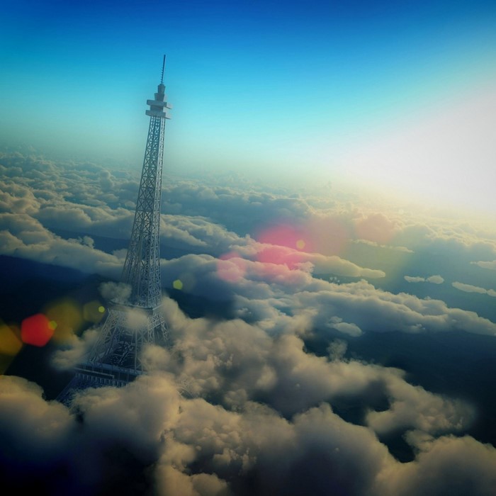 Eiffel Tower above the clouds at sunrise