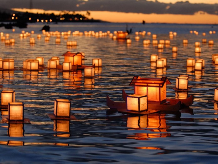 Floating lanterns on the water at sunset