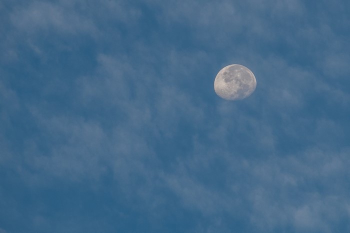The Moon in a cloudy blue sky