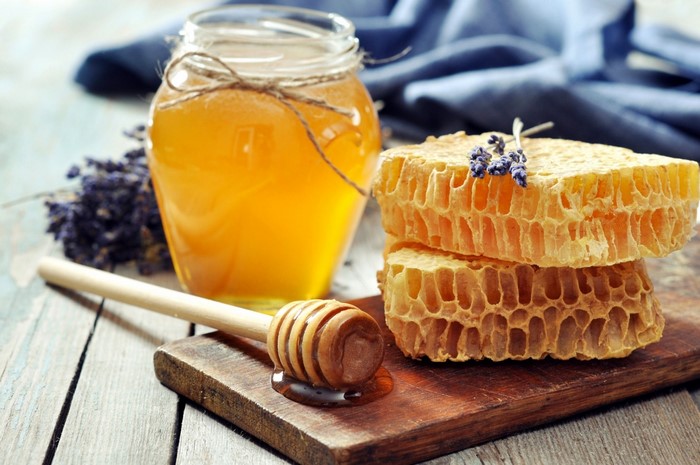 Honey in a jar with honeycomb and dipper