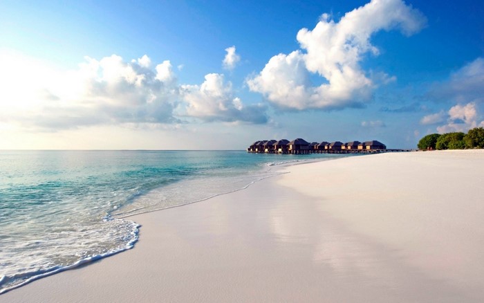 Overwater bungalows on a tropical beach with turquoise water