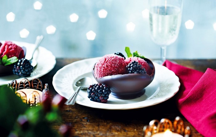 Raspberry sorbet in chocolate bowl with blackberries