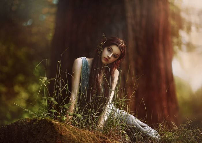 Woman in a dress sitting in a forest