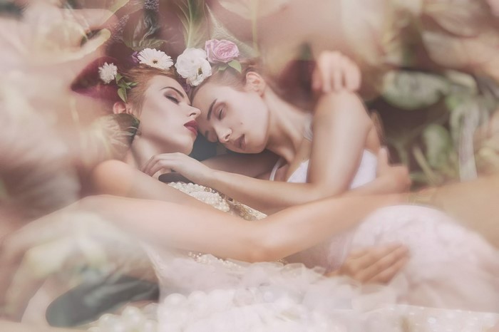 Two women in wedding dresses with flowers
