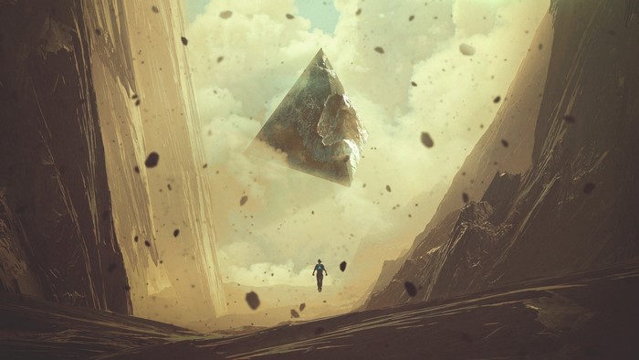 A lone figure walks beneath a floating pyramid in a rocky canyon
