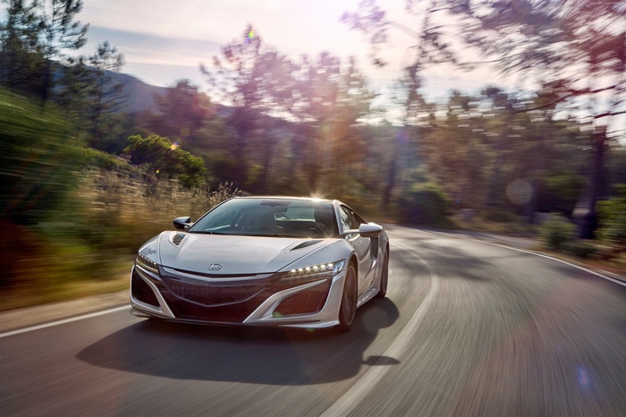 White Honda NSX driving on a winding road