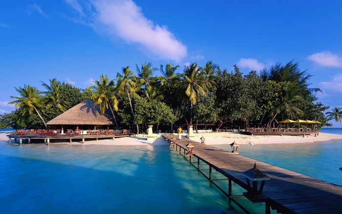 Tropical island resort with pier and thatched-roof restaurant