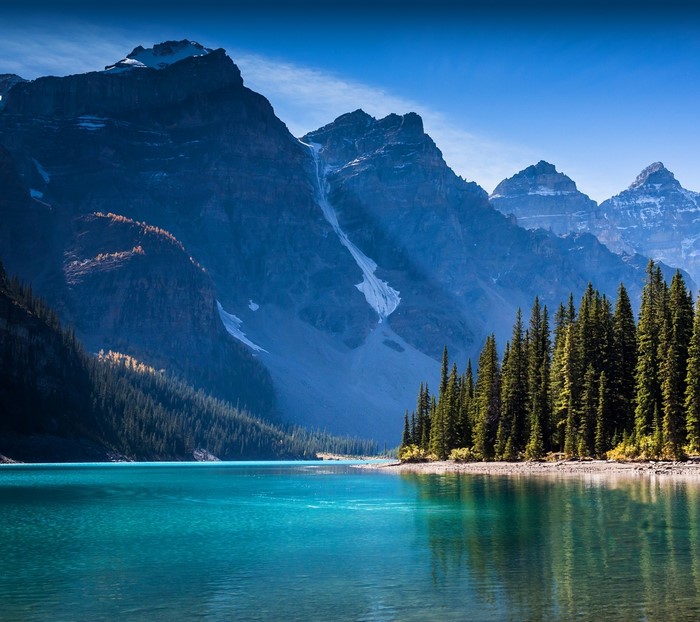 Turquoise lake and mountains with pine trees