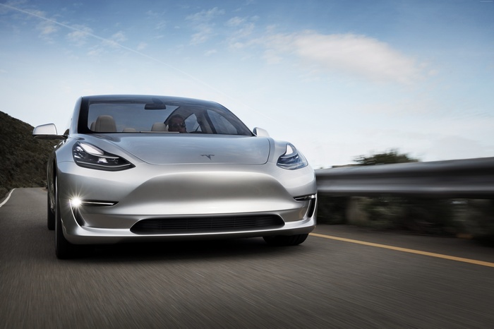 Silver Tesla Model 3 Prototype driving on a road
