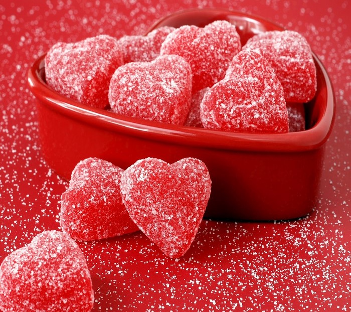 Heart-shaped red candies in a heart-shaped bowl
